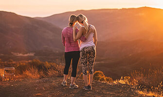 Photo of two women leaning on each other during a hike at sunset for InhousePharmacy.vu homepage