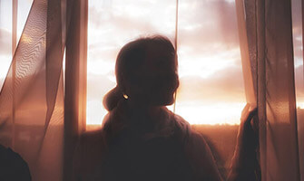 Silhouette of a woman looking outside at sunset on InhousePharmacy.vu homepage